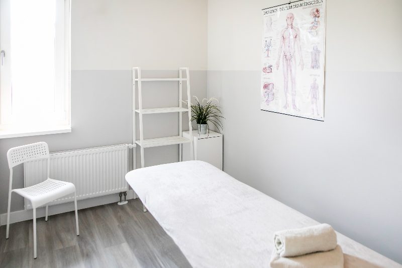 Heller Behandlungsraum der Praxis Südstadt mit Lymphsystem-Lehrtafel
